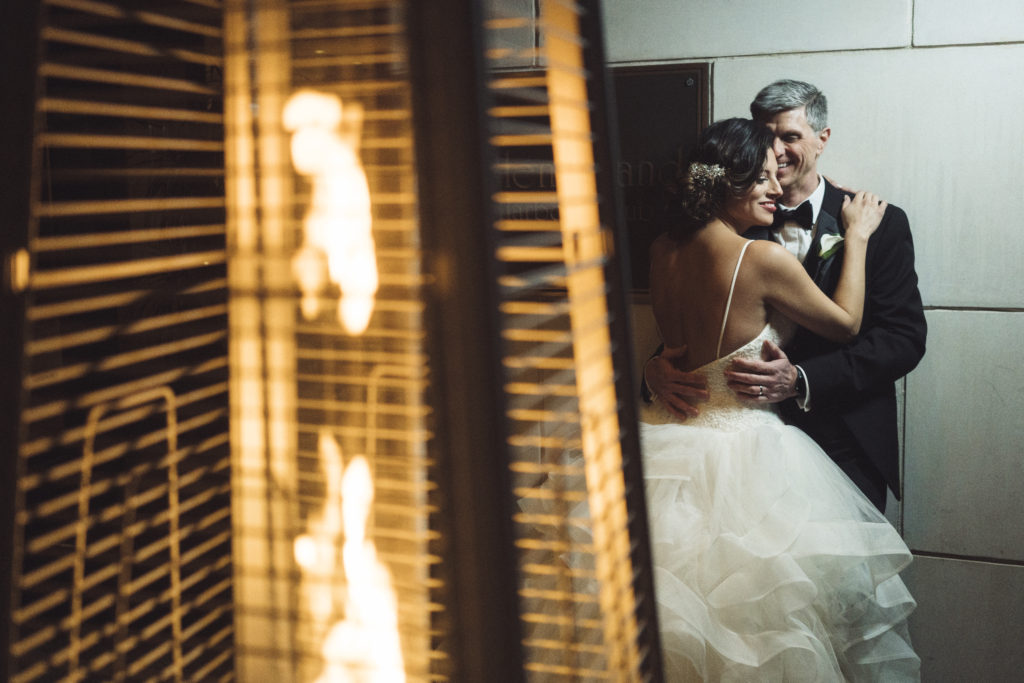 Candid Wedding Photo Of Bride And Groom By Fire