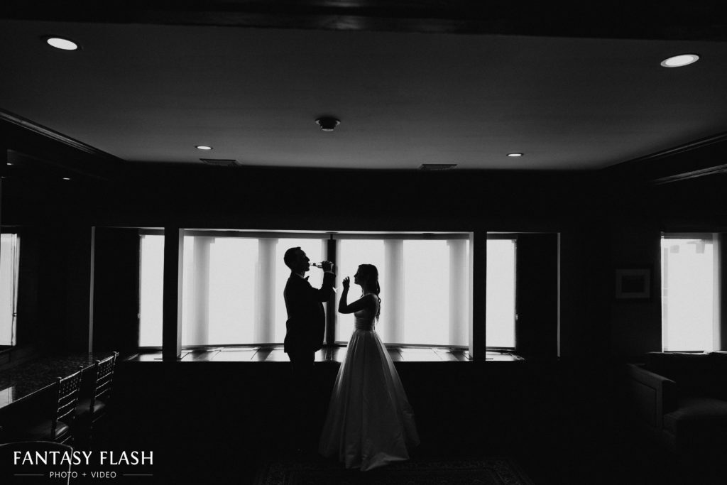 Bride and groom sharing a drink at let chateau in a black and white wedding photo