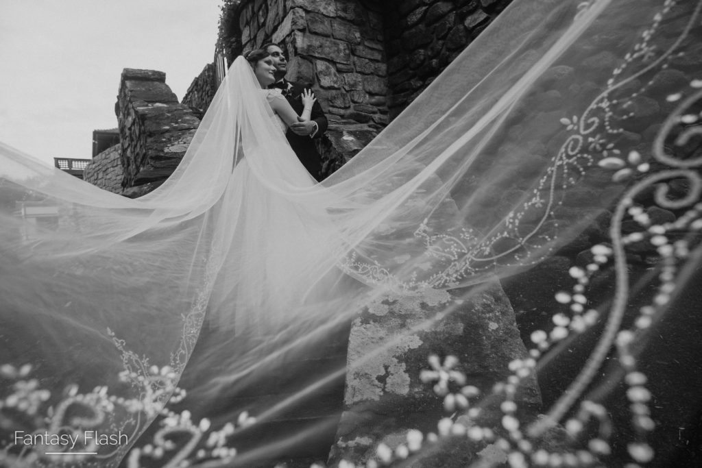 Bride with a long train swept over the stone staircase at Le Chateau