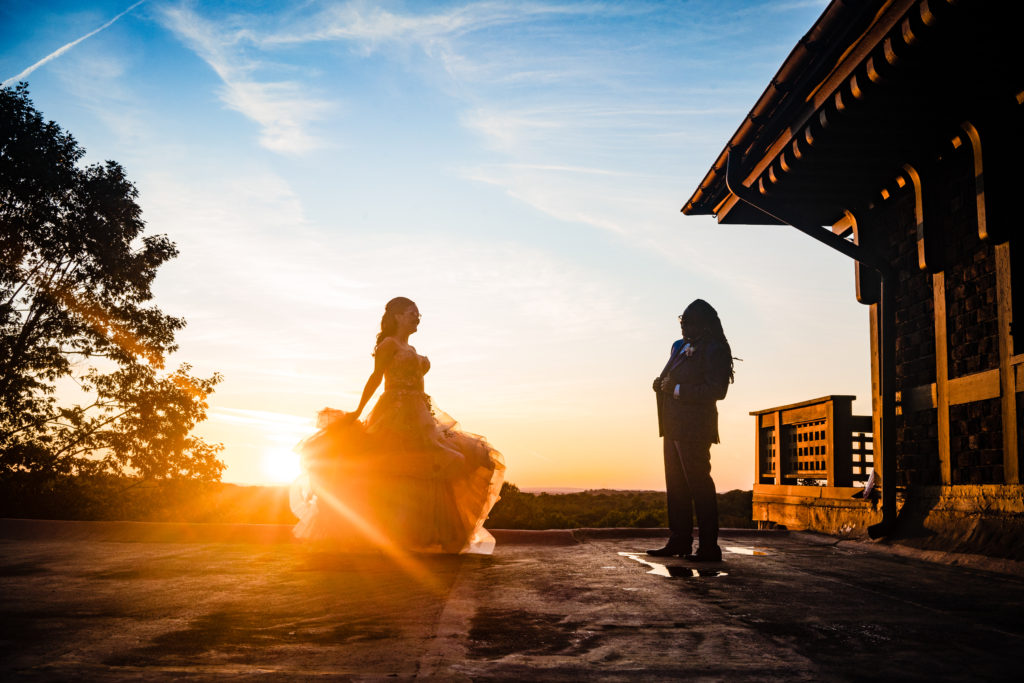 Bride and groom dancing outside in with sunset in background