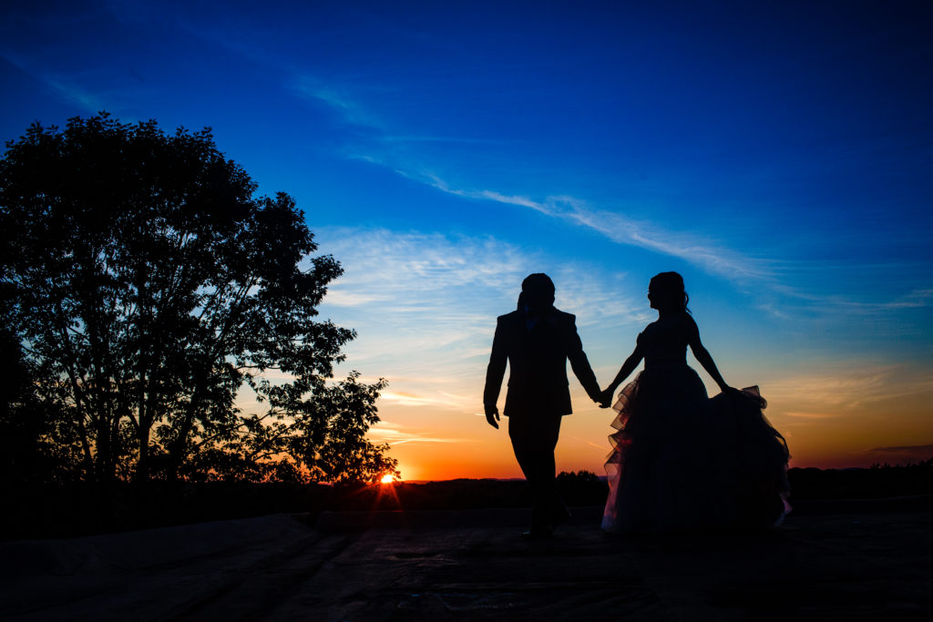 Couple holding hands and walking off into the sunset