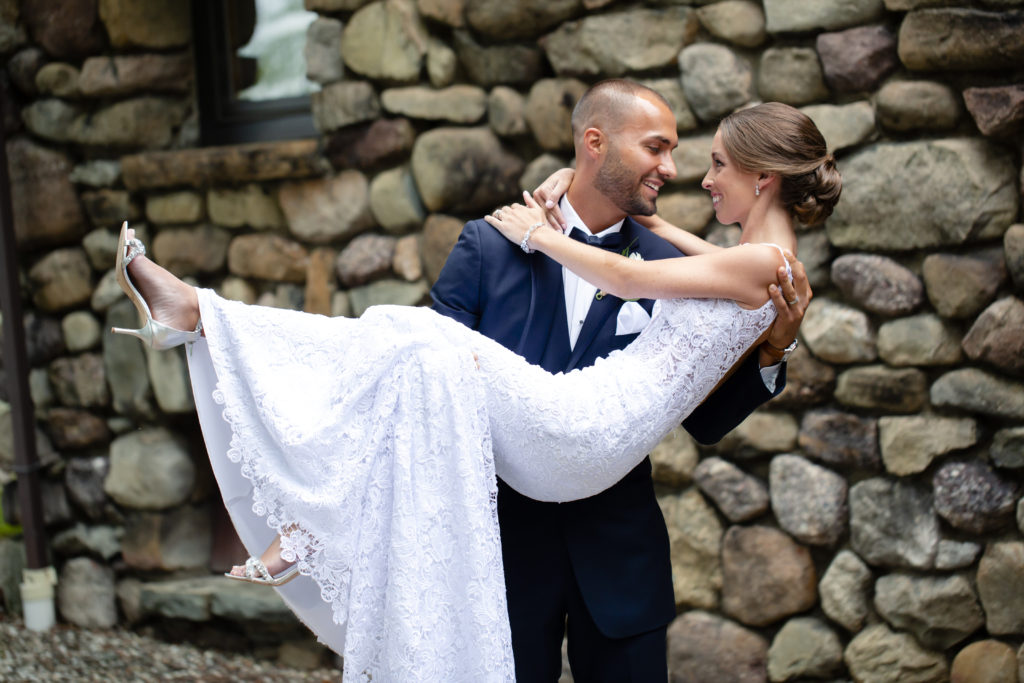 Bride and Groom posing for wedding photo in front of the falkirk estate stone barn