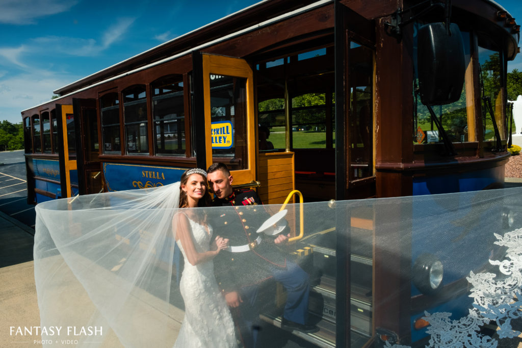 Bride and groom posing in front of trolly to grandview