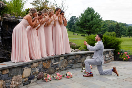 groom down on knee in front of bridal party