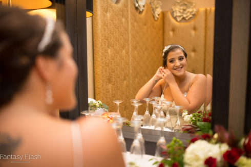 Bride posing in front of mirror in bridal suite