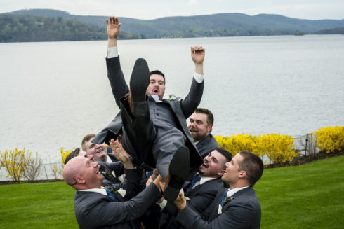 groomsmen tossing the groom in the air