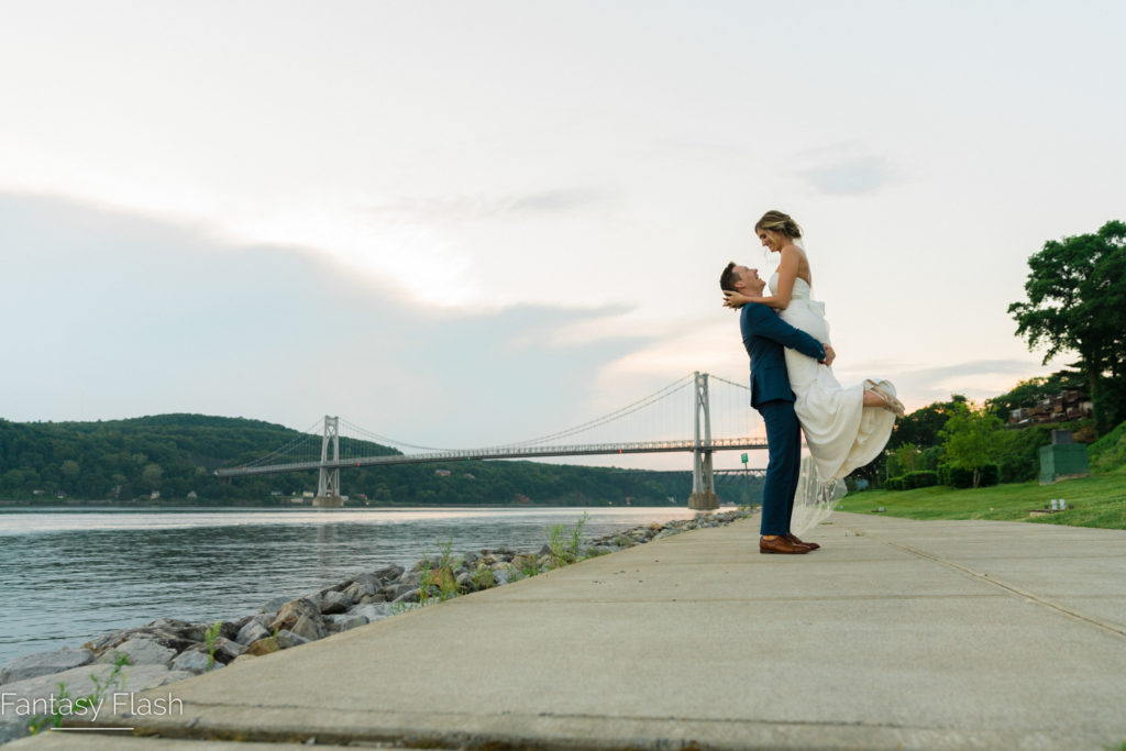 Groom lifting bride in air for wedding portrait