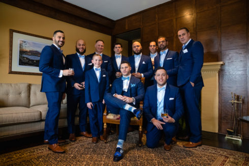 groom with groomsmen posing for wedding photos at le chateau