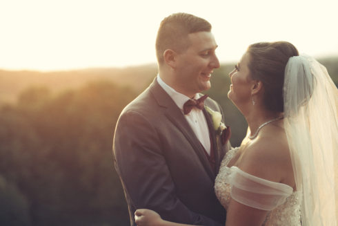 a bride and groom looking each other in the eyes