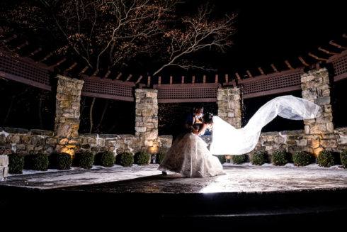 bride and groom backlit for dramatic wedding portrait on the stone patio at le chateau