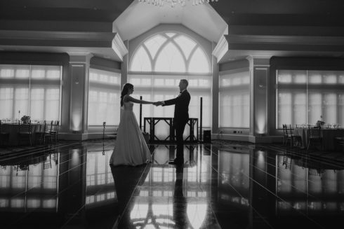 a bride and groom alone in le chateau's main ballroom