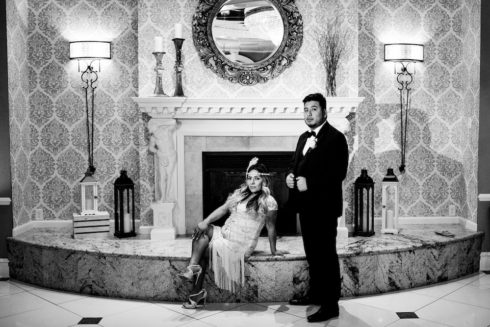 newlywed couple posing in front of fireplace