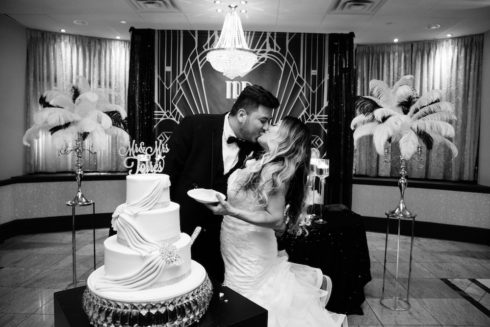 bride and groom kissing by their wedding cake