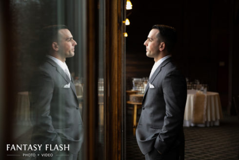 Groom looking at his reflection at the Hollow Brook Golf Club
