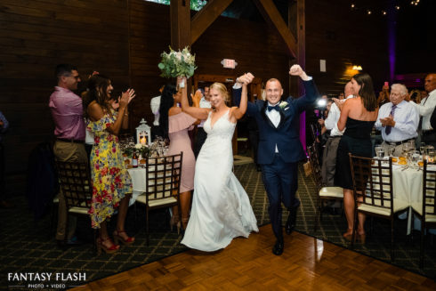 a bride and groom entering their reception at the Hollow Brook Golf Club