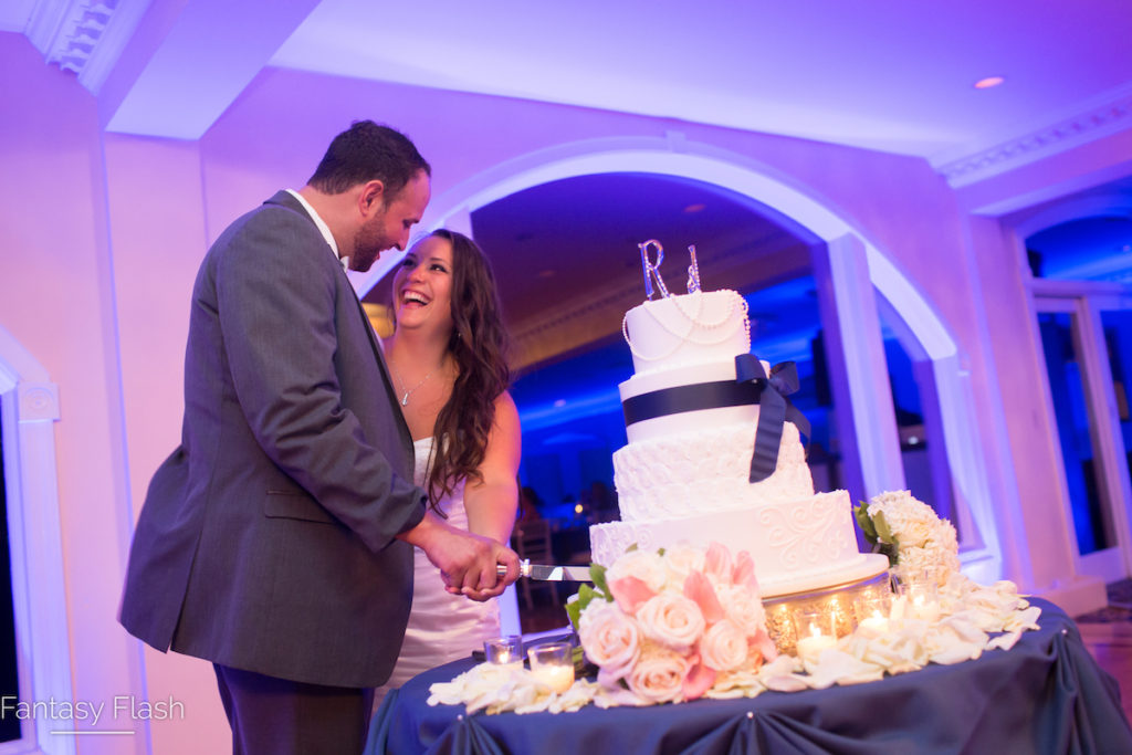 A bride and groom cutting a wedding cake in the main ballroom of Candlewood Inn