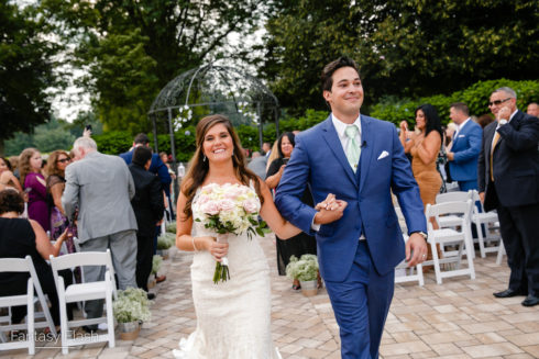 bride and groom walking down isle at West Hills Country Club