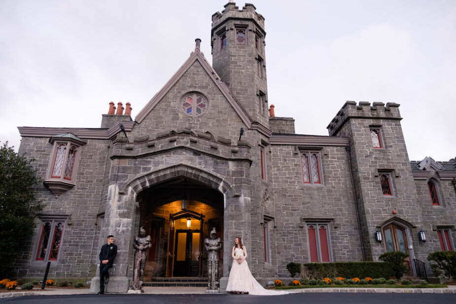 A Bride and groom posing in front of Whitby Castle