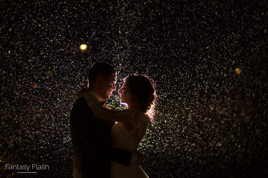 This is a couple standing in the rain on their wedding day.
